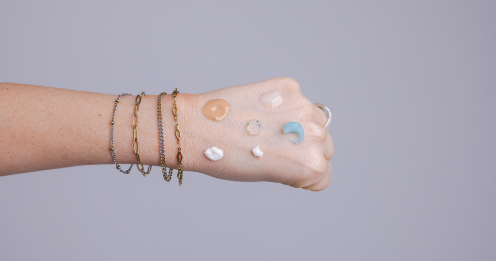 Different skincare product formulas displayed on the back of a hand.